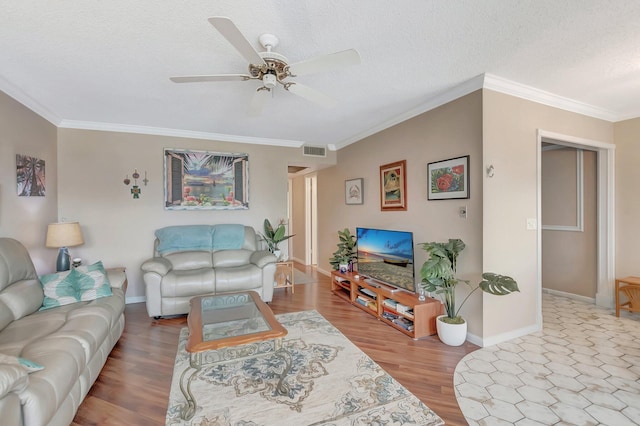 living room featuring visible vents, a ceiling fan, ornamental molding, wood finished floors, and a textured ceiling