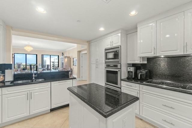 kitchen with a center island, appliances with stainless steel finishes, white cabinetry, and sink