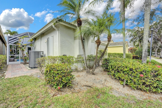 view of property exterior with a patio area, central AC, and a lanai