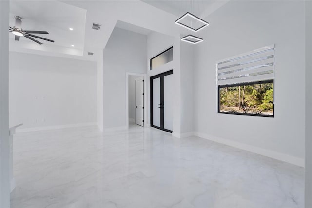 spare room featuring ceiling fan and a high ceiling