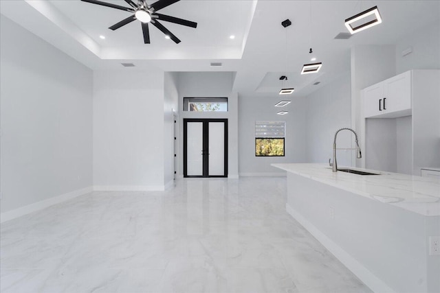 interior space with sink, ceiling fan, and a tray ceiling