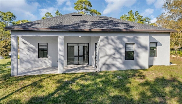 rear view of property featuring a lawn and a patio area