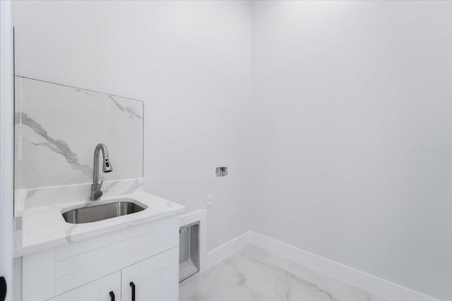 laundry room featuring sink and cabinets