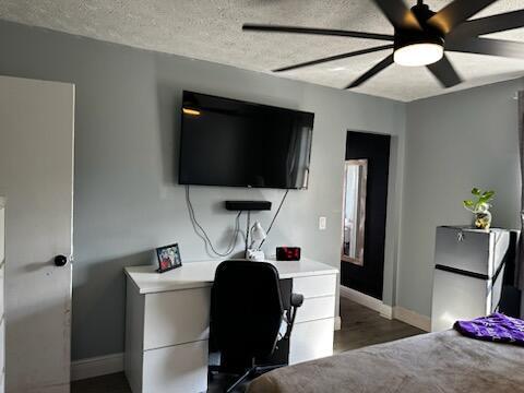 bedroom with a textured ceiling, ceiling fan, wood finished floors, and baseboards