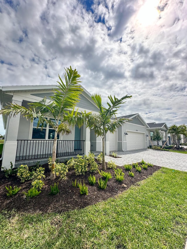 view of front of home featuring a garage, decorative driveway, and stucco siding