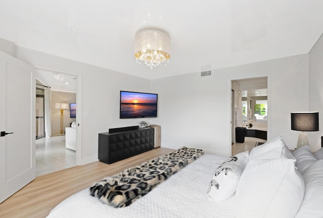 15334 Strathearn Dr Unit 12104, Delray Beach, FL 33446 - bedroom with light wood-type flooring, a chandelier, and connected bathroom