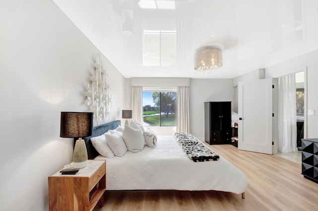 15334 Strathearn Dr Unit 12104, Delray Beach, FL 33446 - bedroom with light wood-style floors, a chandelier, and a towering ceiling