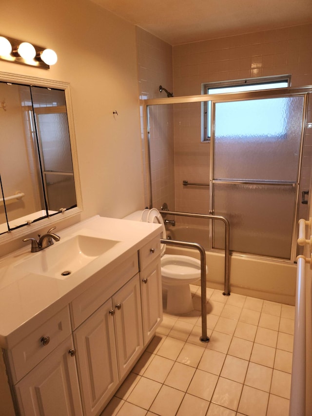 full bathroom with tile patterned floors, vanity, combined bath / shower with glass door, and toilet