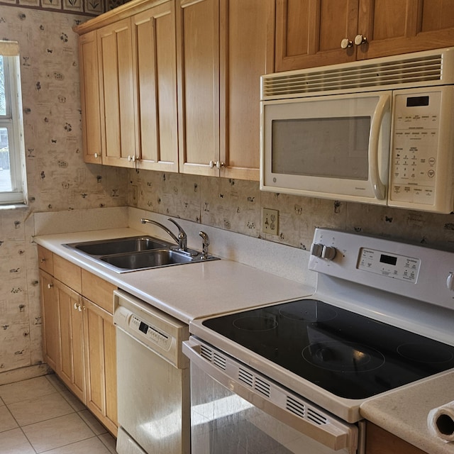 kitchen featuring white appliances, light tile patterned floors, and sink