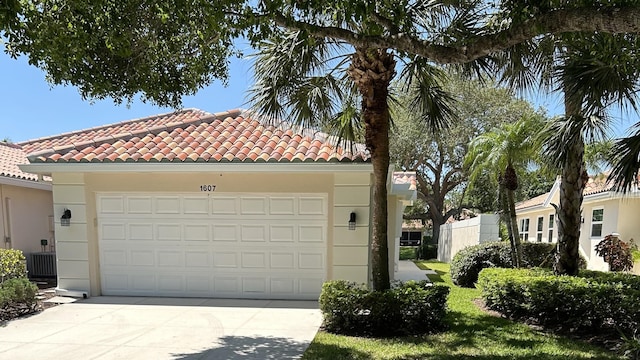 view of front of home featuring a tile roof, driveway, an attached garage, and stucco siding