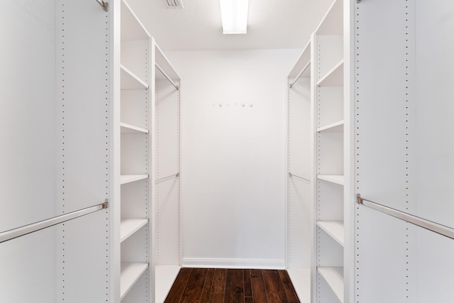 spacious closet with dark wood-type flooring