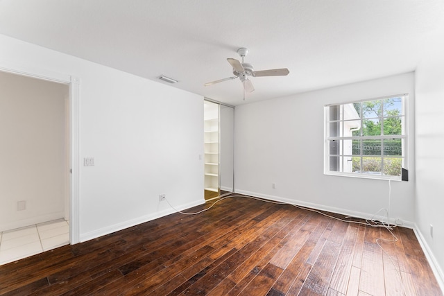 spare room with hardwood / wood-style flooring, ceiling fan, and baseboards