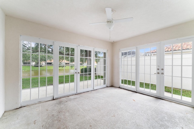 unfurnished sunroom with ceiling fan and french doors