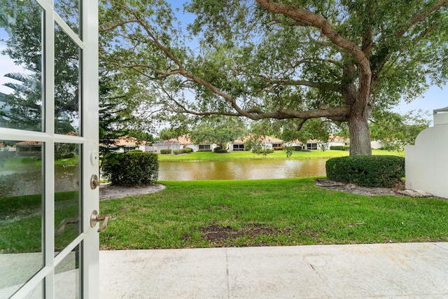 view of green lawn with a water view