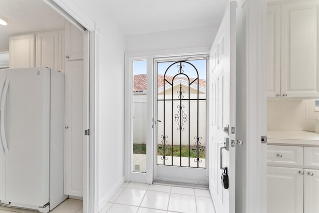 doorway to outside with baseboards and light tile patterned floors