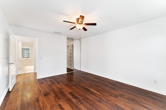 empty room featuring ceiling fan, dark wood-style flooring, and baseboards