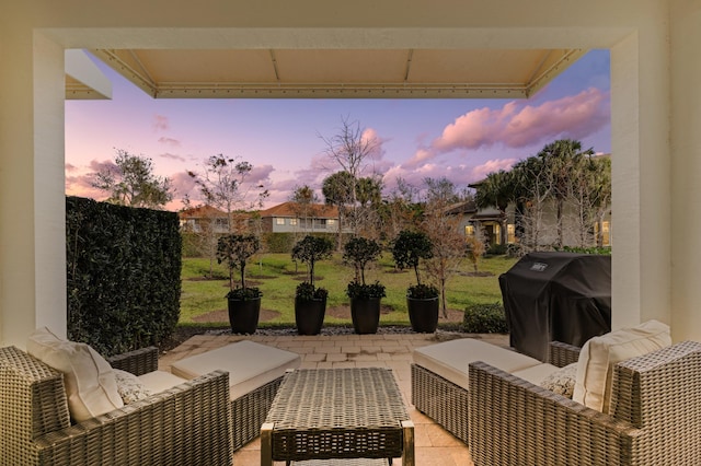 patio terrace at dusk featuring grilling area and outdoor lounge area