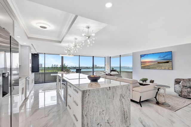 kitchen with white cabinetry, crown molding, a kitchen island, and floor to ceiling windows