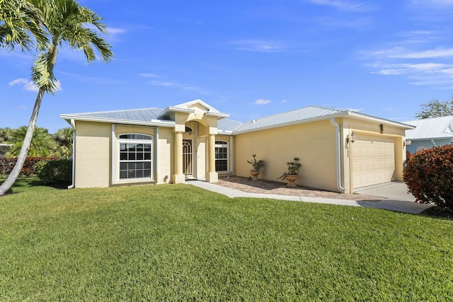 view of front facade with an attached garage, a front yard, metal roof, and stucco siding