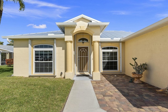 property entrance featuring a standing seam roof, metal roof, and stucco siding