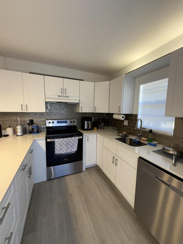 kitchen featuring hardwood / wood-style flooring, sink, stainless steel appliances, and white cabinetry