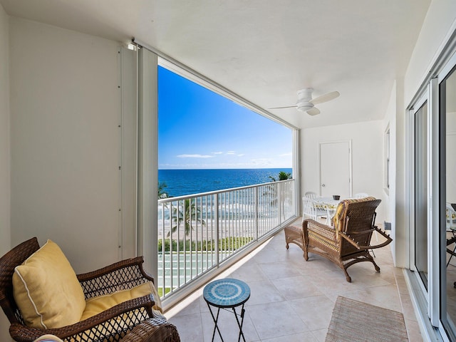 balcony featuring a water view and ceiling fan