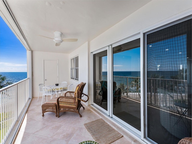 balcony featuring a water view and ceiling fan