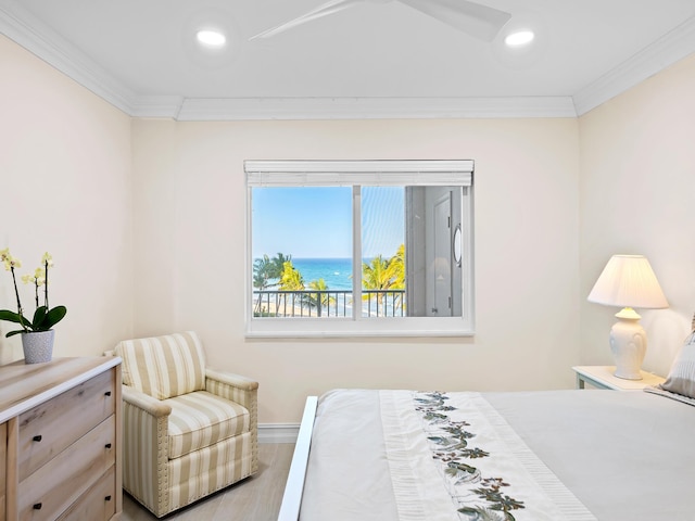 bedroom featuring ornamental molding, a water view, and wood-type flooring