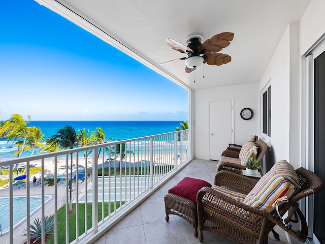 balcony with ceiling fan, a water view, and a beach view