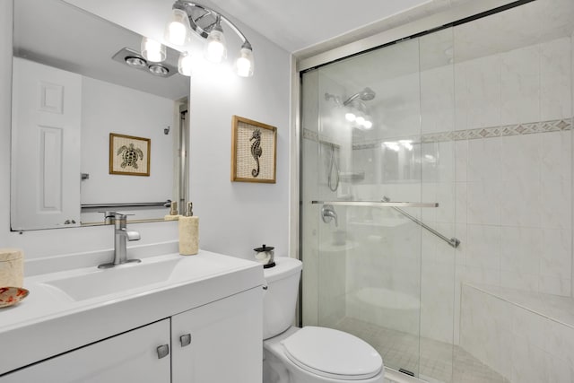 full bathroom with vanity, a shower stall, and toilet