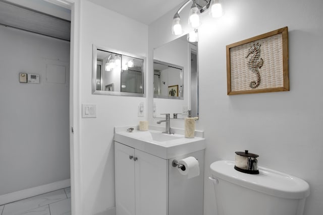 bathroom with marble finish floor, toilet, vanity, and baseboards