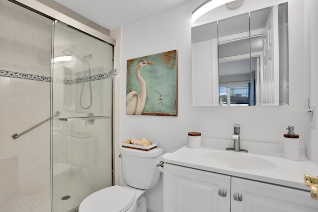 bathroom featuring a stall shower, vanity, and toilet