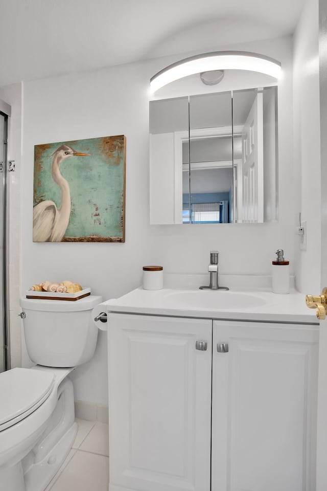 bathroom featuring toilet, vanity, baseboards, and tile patterned floors