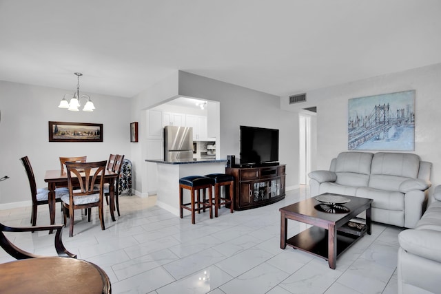 living room featuring baseboards, marble finish floor, visible vents, and a notable chandelier