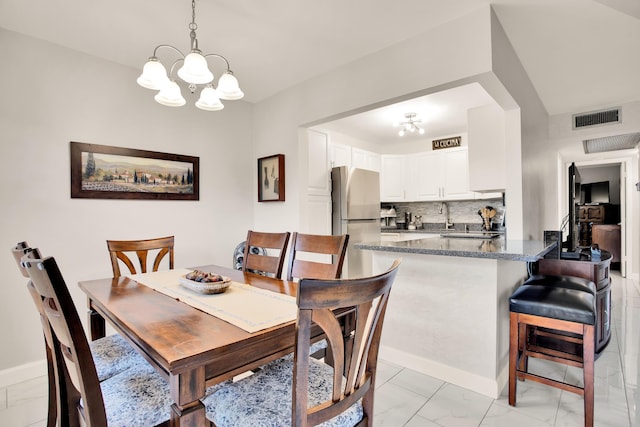 dining space featuring marble finish floor, baseboards, visible vents, and an inviting chandelier