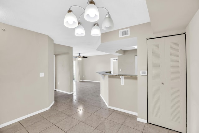 kitchen with baseboards, visible vents, a ceiling fan, a breakfast bar area, and light tile patterned flooring