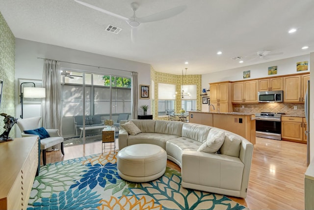 living room featuring recessed lighting, visible vents, ceiling fan, and light wood-style flooring