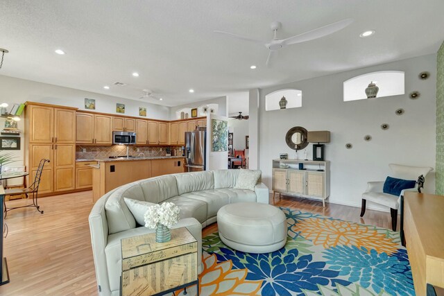 living area with ceiling fan, recessed lighting, and light wood-style floors