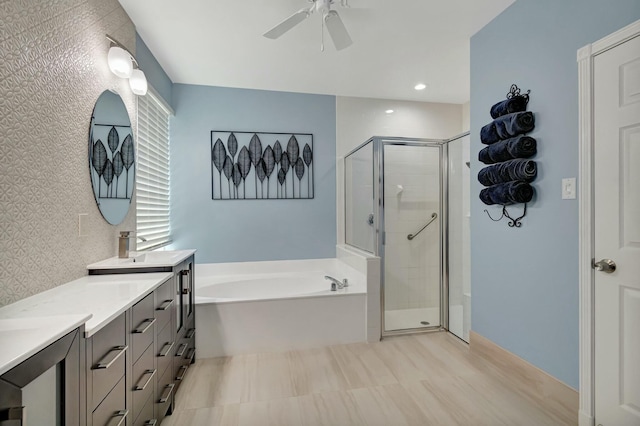 full bathroom featuring double vanity, a stall shower, a garden tub, and a ceiling fan