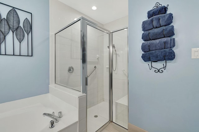full bathroom with a stall shower, a garden tub, and recessed lighting