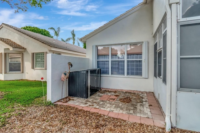 view of side of property with a patio and stucco siding