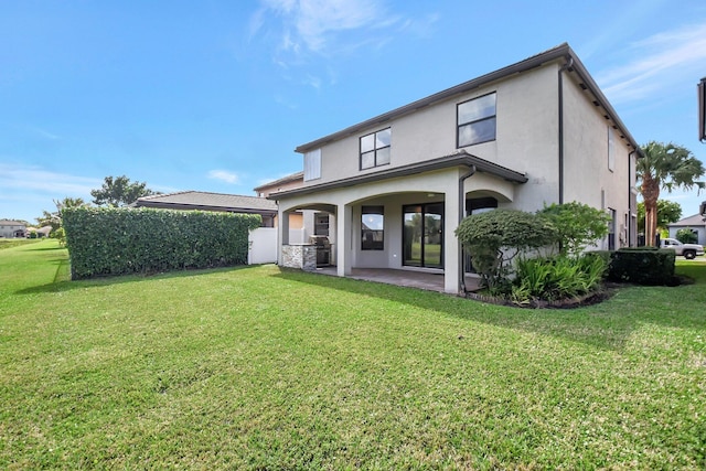 back of property featuring a patio and a yard