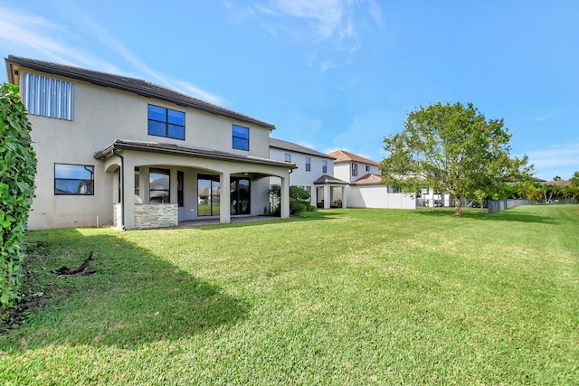 back of property with a patio and a yard