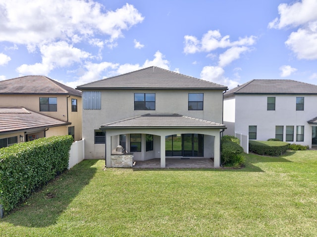 back of house featuring a yard, an outdoor kitchen, and a patio area