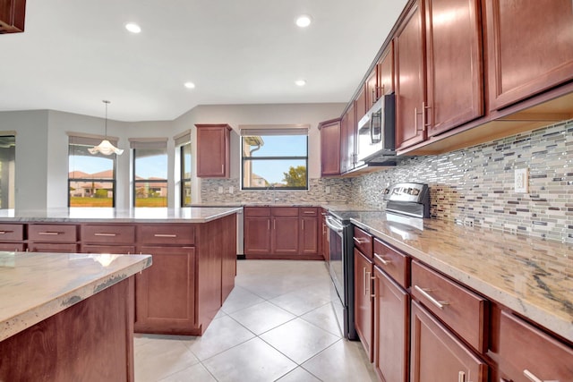 kitchen with appliances with stainless steel finishes, tasteful backsplash, hanging light fixtures, light stone countertops, and light tile patterned floors