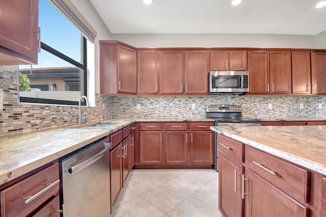 kitchen featuring sink, backsplash, appliances with stainless steel finishes, and light tile patterned floors