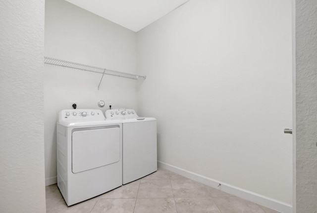 washroom featuring light tile patterned flooring and washing machine and clothes dryer