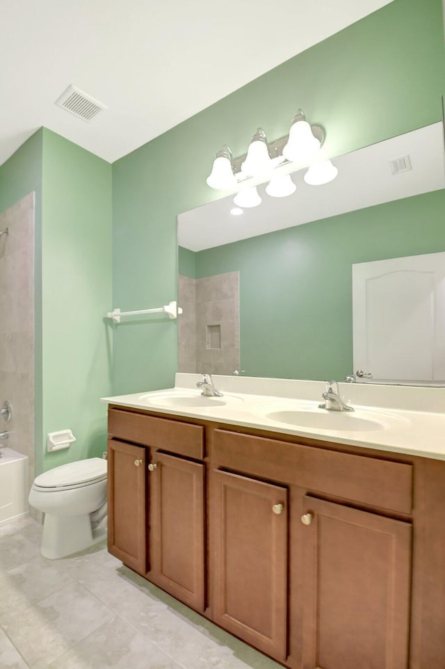 full bathroom with tiled shower / bath combo, vanity, tile patterned flooring, and toilet