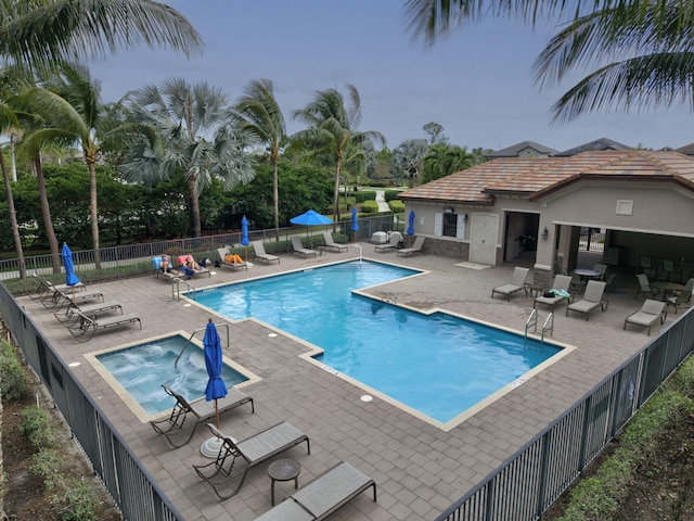 view of pool with a hot tub and a patio