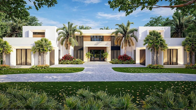 view of front of home featuring stucco siding, driveway, and a front lawn